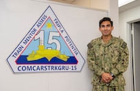 Lt. Anthony Matus, from Yuma, Ariz., stands in front of the entrance of Commander, Carrier Strike Group (CCSG) 15. CCSG-15 conducts integrated training to provide Fleet Commanders with deployable combat ready maritime forces in support of global operations.