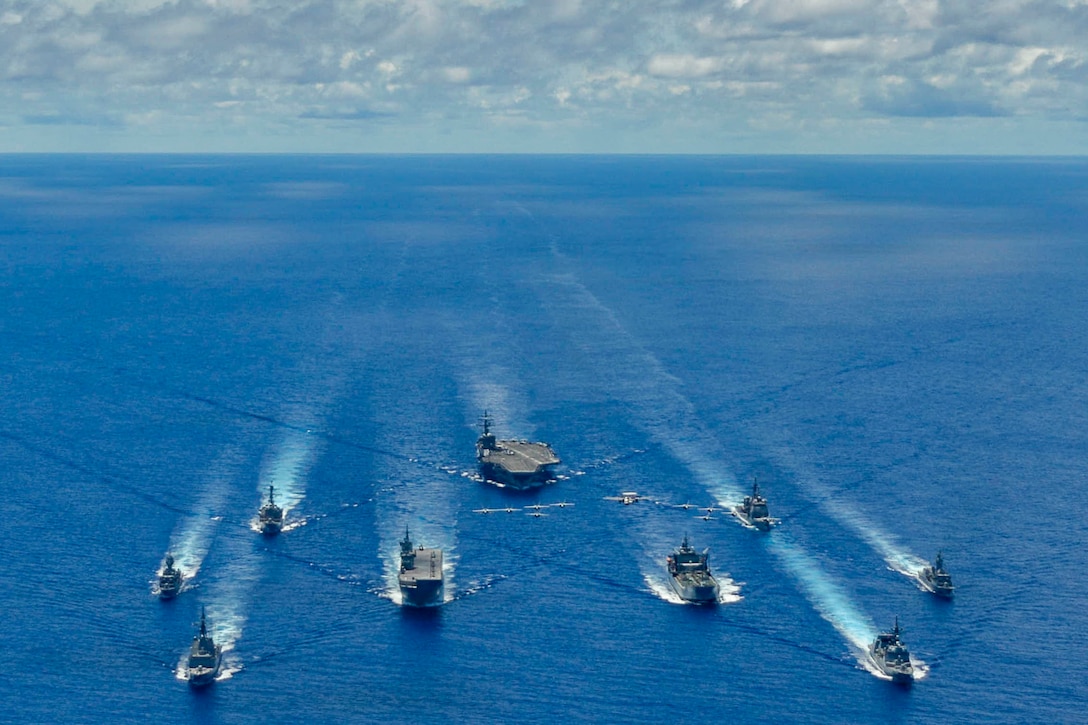 A large group of ships sail in formation.