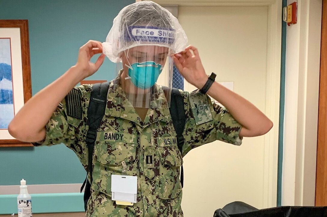 A sailor puts on protective gear.