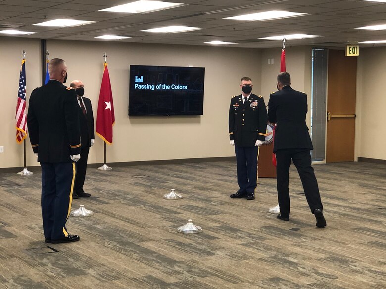 Brig. Gen. Peter D. Helmlinger accepts the colors (flag) from Col. Arron L. Dorf transferring leadership to incoming commander Col. Michael D. Helton