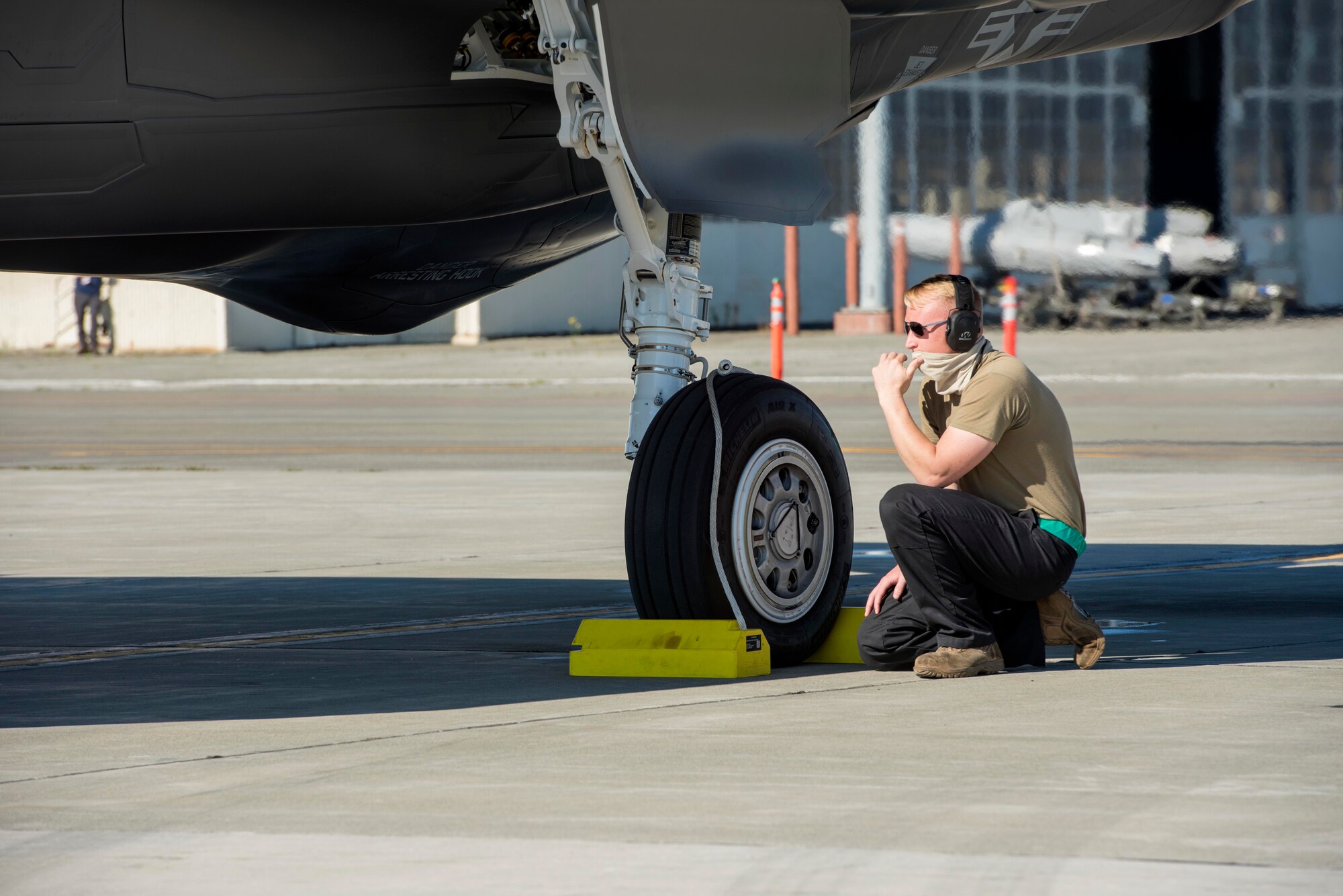 Tech. Sgt. Tyler Sherman, a 354th Aircraft Maintenance Squadron crew chief assigned to Eielson Air Force Base, Alaska, prepares to remove aircraft chocks from an F-35 Lightning II before takeoff at Joint Base Elmendorf-Richardson, Alaska, July 14, 2020.