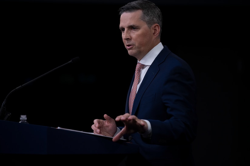 A man standing at a lectern speaks.