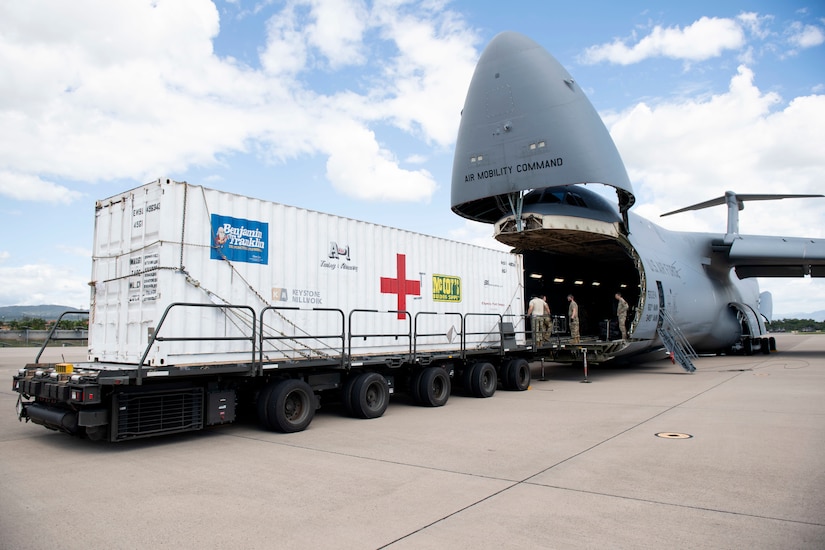 U.S. Airmen assigned to the 22nd Airlift Squadron, Travis Air Force Base, California, off-load a T6 container July 18, 2020, at Soto Cano Air Base, Honduras. The T6 container held 17,000 pounds of COVID-19 medical supplies for Honduras communities. (U.S. Air Force photo by Senior Airman Jonathon Carnell)