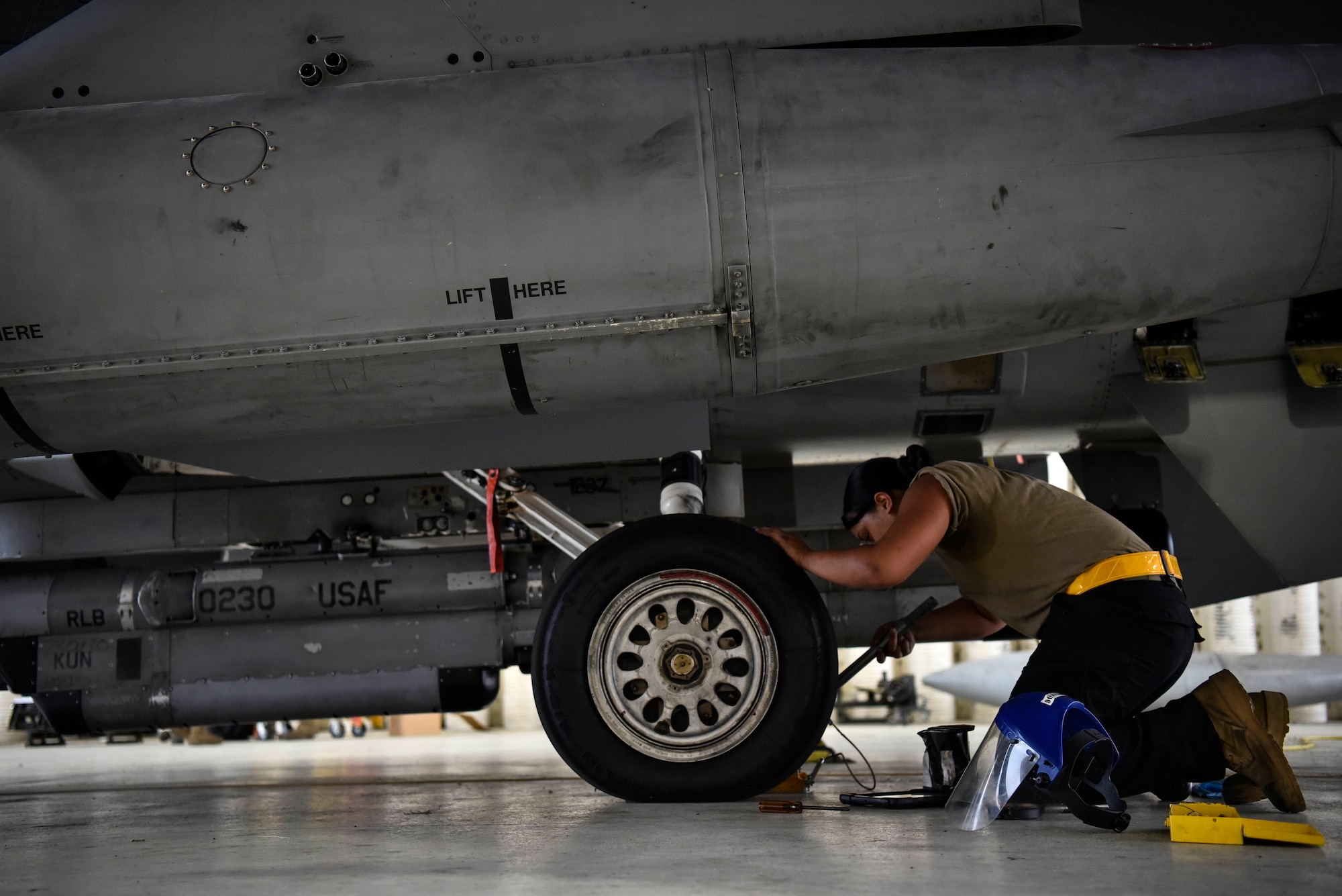 A photo of an Airman using a hydraulic jack.