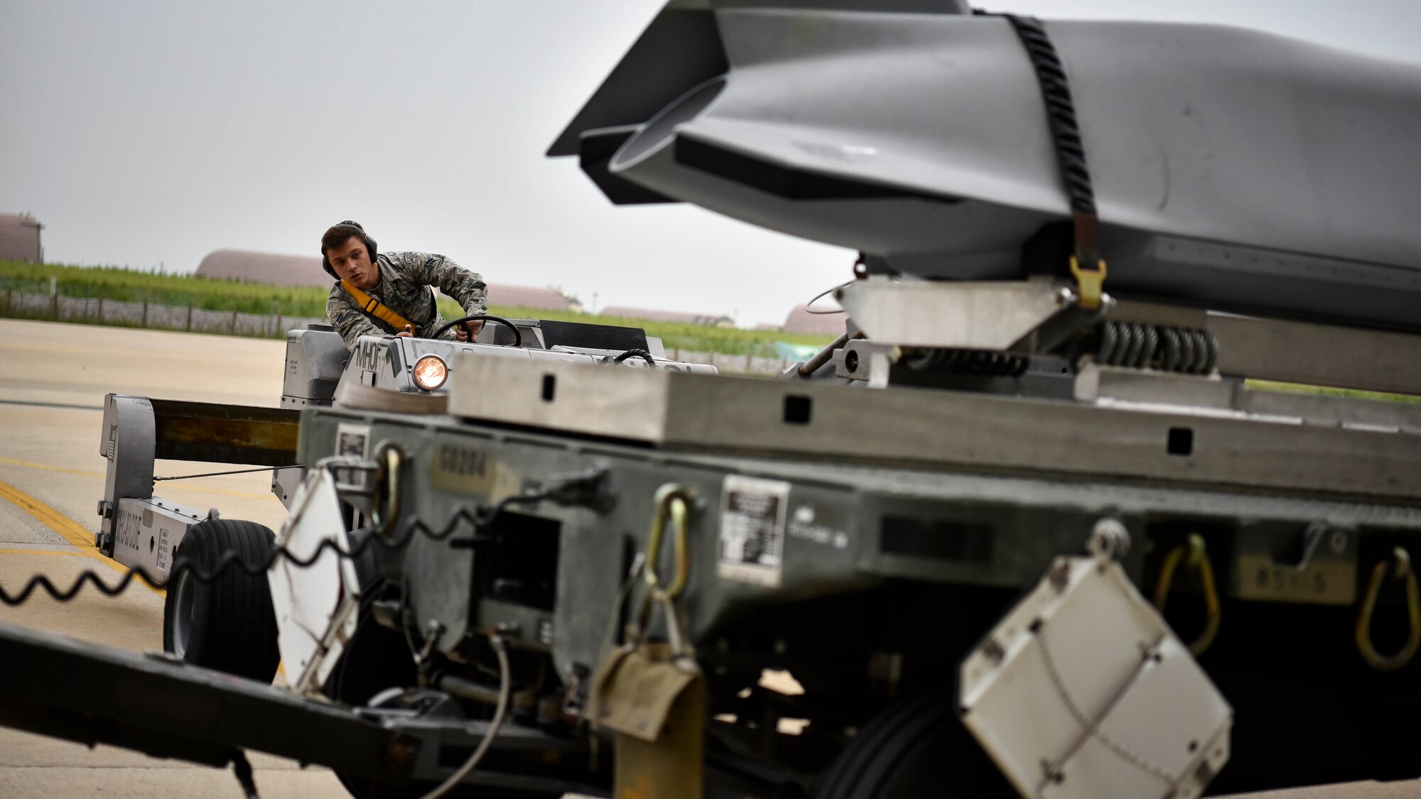 A photo of an Airman loading a missile onto an aircraft.
