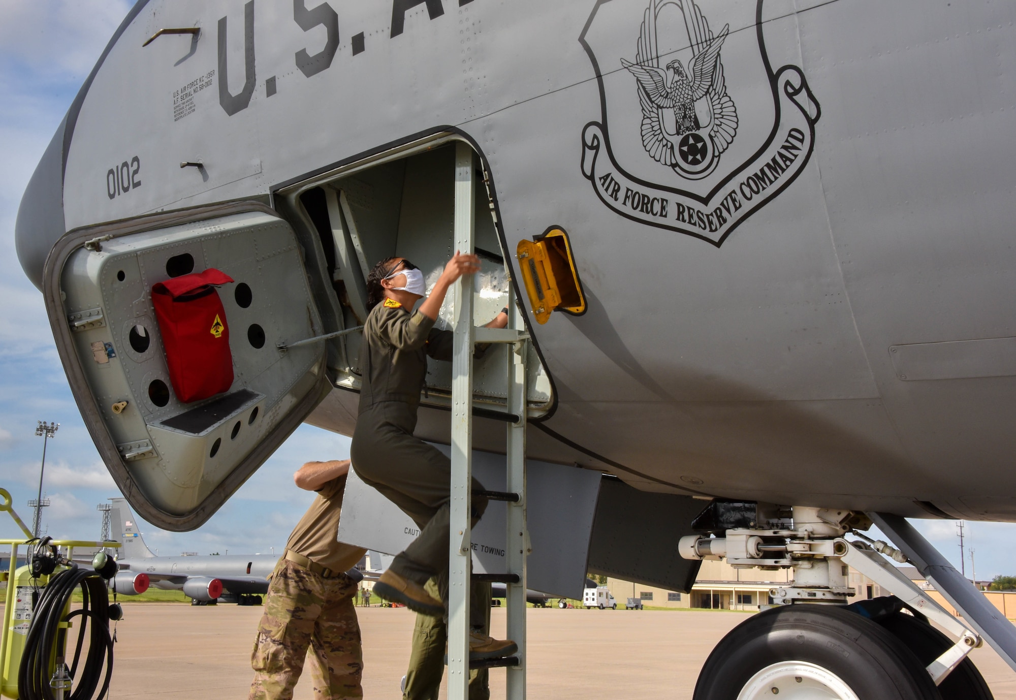 2nd Lt. Keisha Holback, 465th Air Refueling Squadron pilot, climbs into the flight deck of a KC-135R Stratotanker July 21, 2020, at Tinker Air Force Base, Oklahoma. Pilots are required to wear personal protective equipment to mitigate the spread of COVID-19. (U.S. Air Force photo by Senior Airman Mary Begy)