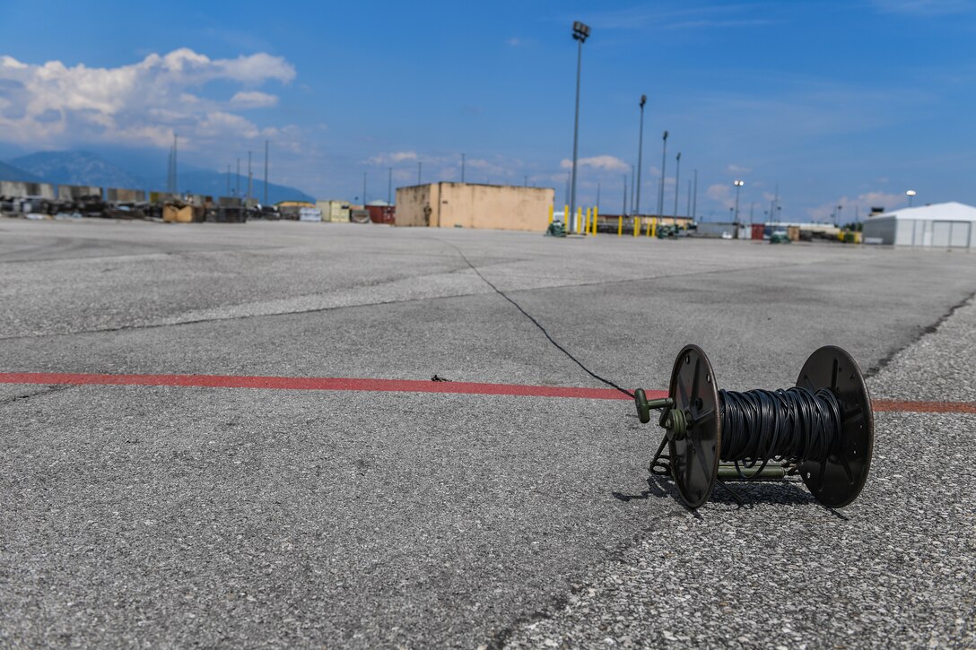 A spool of detonation cord sits on the ground during explosive ordnance disposal training at Aviano Air Base, Italy, July 15, 2020. EOD technicians used the detonation cord to safely set off a block of C4 during a monthly training. EOD detects, identifies, recovers, disarms and disposes of unsafe explosives and ordnance. (U.S. Air Force photo by Airman 1st Class Thomas S. Keisler IV)