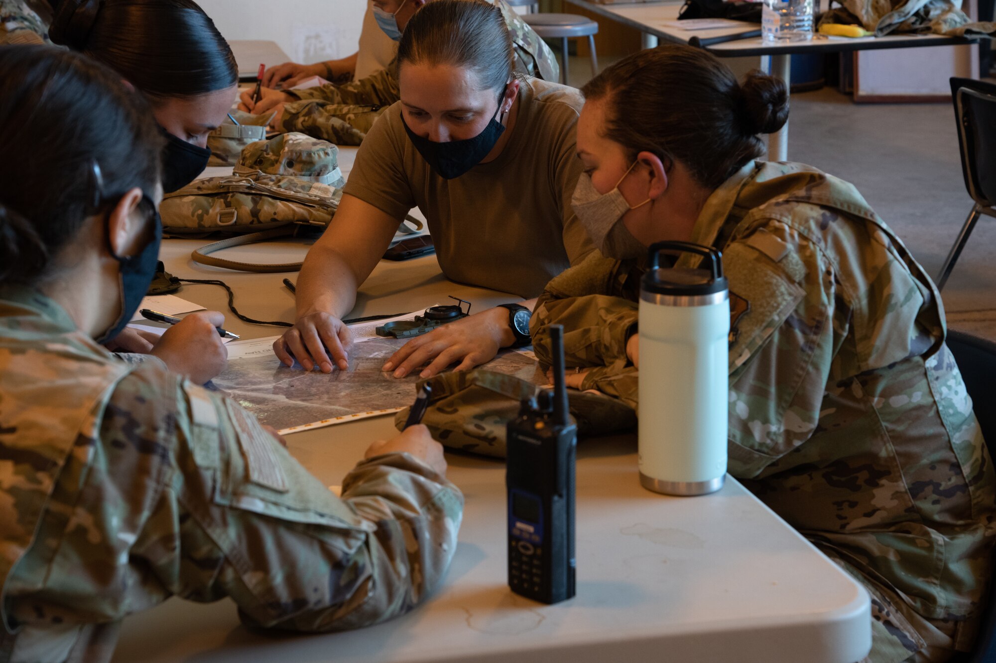 Group of Airmen review a topographical map during class instruction.