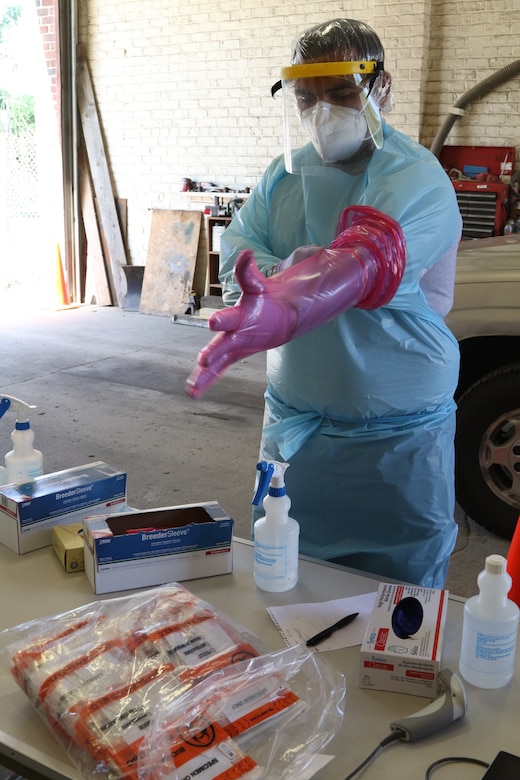 A man puts on full body protective gear.