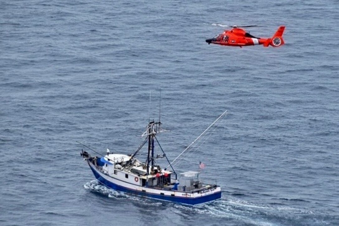 A Coast Guard aircrew medically evacuates a man from a fishing vessel operating 100 miles west of Coos Bay, Oregon, July 11, 2020. The aircrew hoisted the injured fisherman safely and transferred him to emergency medical services personnel. (U.S. Coast Guard photo by Petty Officer 3rd Class Ben Loy)