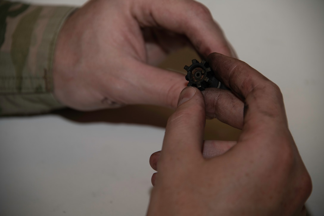 U.S. Air Force Capt. Gregory Speirs, 621st Contingency Response Wing judge advocate, inspects a bolt from an M-4 carbine rifle at Travis Air Force Base, California, May 27, 2020. Speirs is one of the more than 3,000 Airmen who complete weapons training at the 60th Security Forces Squadron combat arms training and maintenance range each year. (U.S. Air Force photo by Tech. Sgt. James Hodgman)