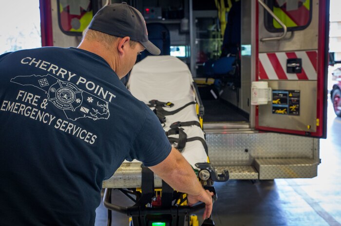 Dale Askew pulls out a stretcher from the back of an ambulance at Marine Corps Air Station Cherry Point, N.C., June 29.