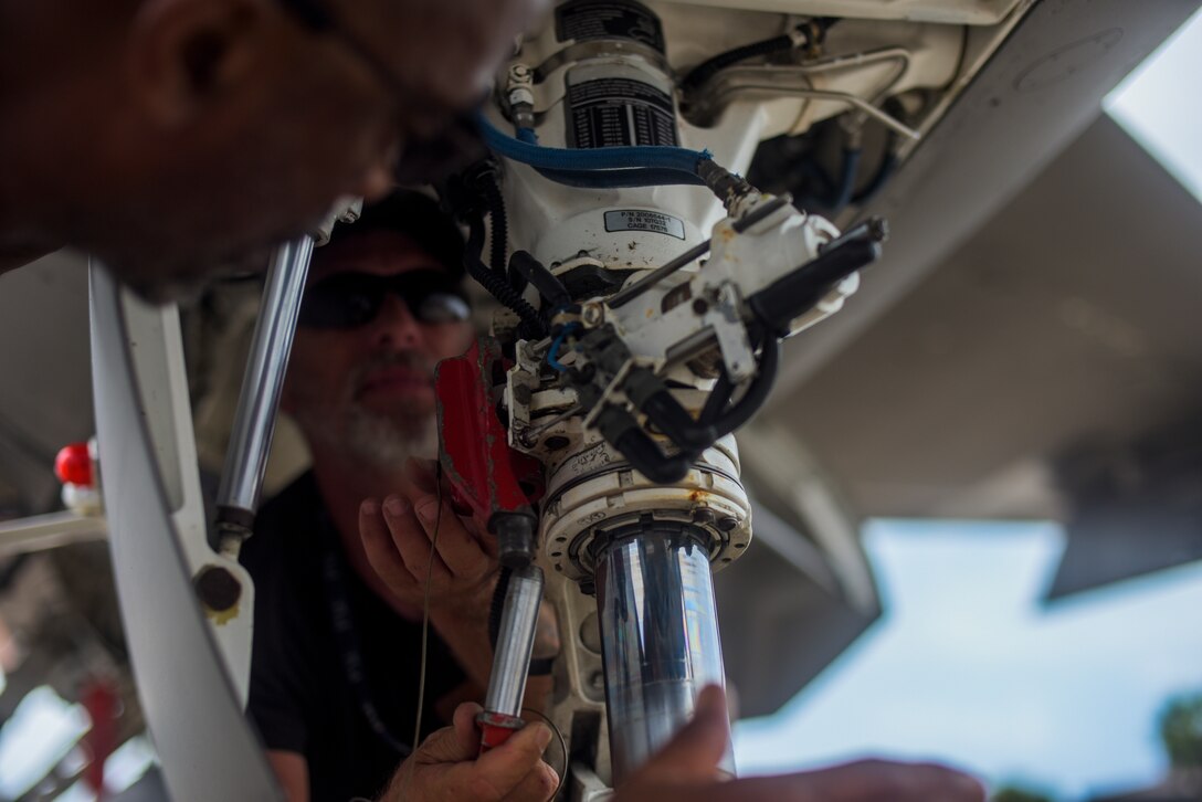 Dan Jones, right, and Jim Holland, left, with the 82nd Aerial Targets Squadron, contractors, work on the front landing gear of a QF-16 at Tyndall Air Force Base, Florida, July 9, 2020. Performance and maintenance checks are completed before and after every aircraft take off to ensure mission effectiveness and pilot safety. (U.S. Air Force photo by Staff Sgt. Magen M. Reeves)