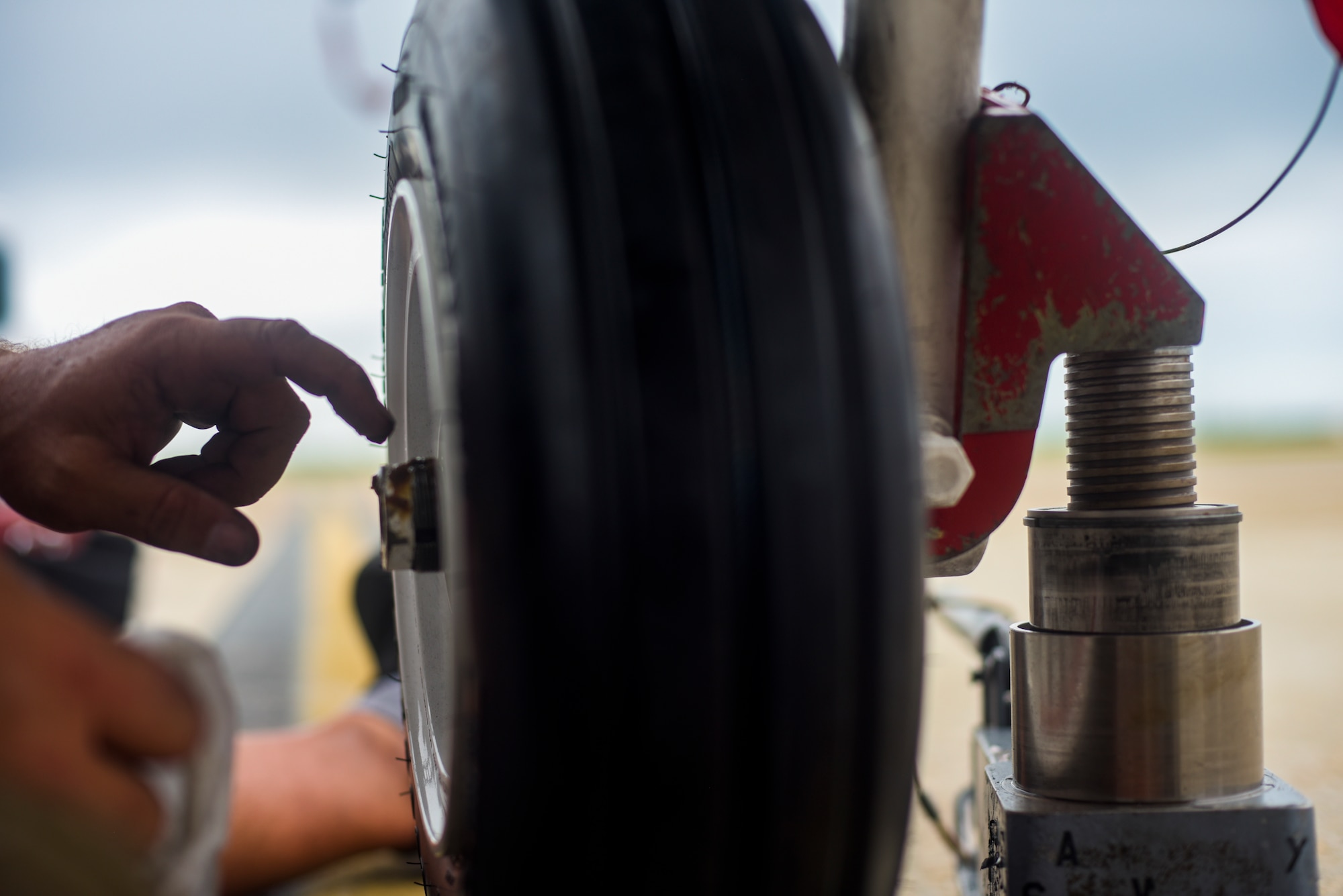 Michael Reeves with the 82nd Aerial Targets Squadron, contractor, places a grease-based lubricant on the front landing gear of a QF-16 at Tyndall Air Force Base, Florida, July 9, 2020. The 82nd ARTS contractors fulfill a variety of different flight line technical skills, including replacing old or malfunctioning landing gear. (U.S. Air Force photo by Staff Sgt. Magen M. Reeves)