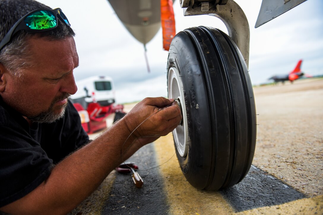 Michael Reeves with the 82nd Aerial Targets Squadron, contractor, works to replace the front landing tire on a QF-16 at Tyndall Air Force Base, Florida, July 9, 2020. The 82nd ARTS contractors fulfill a variety of different flight line technical skills including replacing old or malfunctioning landing gear. (U.S. Air Force photo by Staff Sgt. Magen M. Reeves)
