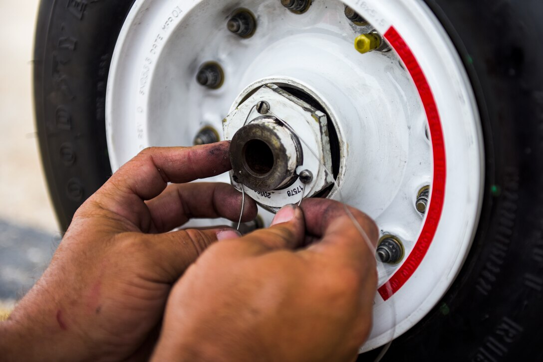 Michael Reeves with the 82nd Aerial Targets Squadron, contractor, works to rethread the wiring on the front landing tire on a QF-16 at Tyndall Air Force Base, Florida, July 9, 2020. The 82nd ARTS contractors fulfill a variety of different flight line technical skills, including replacing old or malfunctioning landing gear. (U.S. Air Force photo by Staff Sgt. Magen M. Reeves)