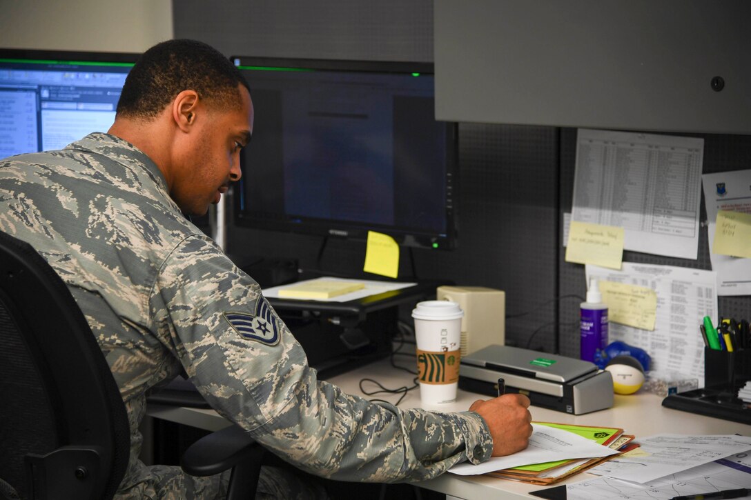 An airman sits at a desk during telework.