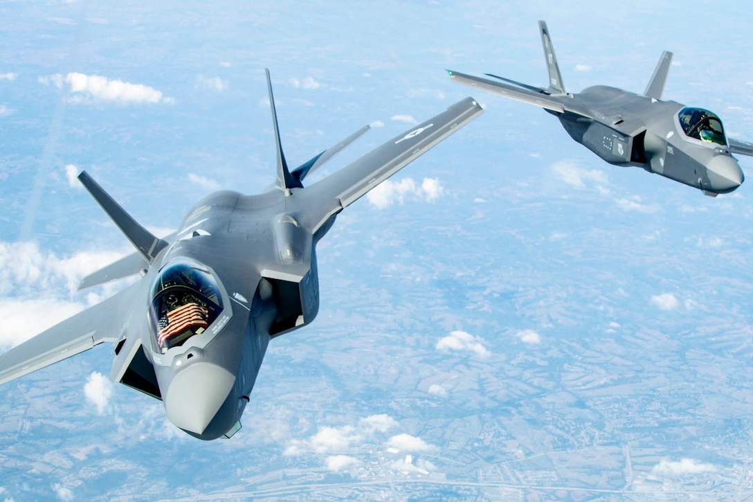 Two military fighter aircraft fly in formation.