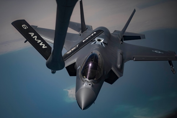 A military aircraft approaches a refueling boom.