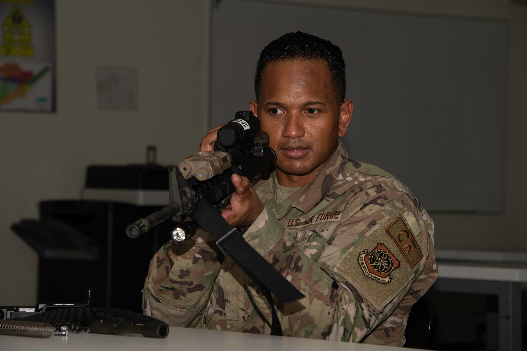 U.S. Air Force Master Sgt. Frank Monsegue, 921st Contingency Response Squadron maintenance flight chief, inspects an M-4 carbine rifle during a weapons training class at Travis Air Force Base, California, May 27, 2020. The 60th Security Forces Squadron combat arms training and maintenance section trains more than 3,000 Airmen each year on 10 weapon systems. (U.S. Air Force photo by Tech. Sgt. James Hodgman)