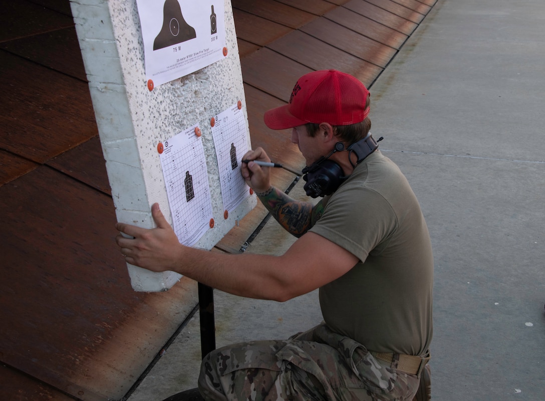 U.S. Air Force Staff Sgt. Victor Bouhot, 60th Security Forces Squadron combat arms training and maintenance instructor, scores a target during an M-4 Rifle/Carbine Air Force qualification class May 27, 2020, at Travis Air Force Base, California. The 60th SFS CATM section trains more than 3,000 Airmen on 10 weapon systems each year. (U.S. Air Force photo by Tech. Sgt. James Hodgman)