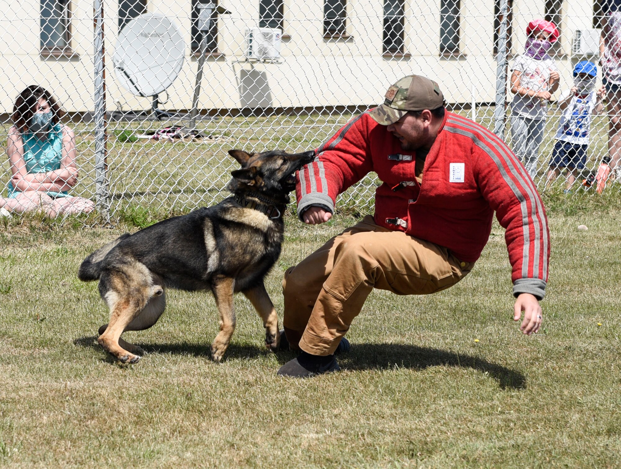 U.S. Air Force Senior Airman Erik Barrera, 52nd Security Forces Squadron military working dog handler, and Axel, an MWD, conduct an intruder exercise at Spangdahlem Air Base, Germany, July 22, 2020. The 52nd SFS MWD handlers performed a demonstration for Spangdahlem AB families and their children. (U.S. Air Force photo by Senior Airman Melody W. Howley)