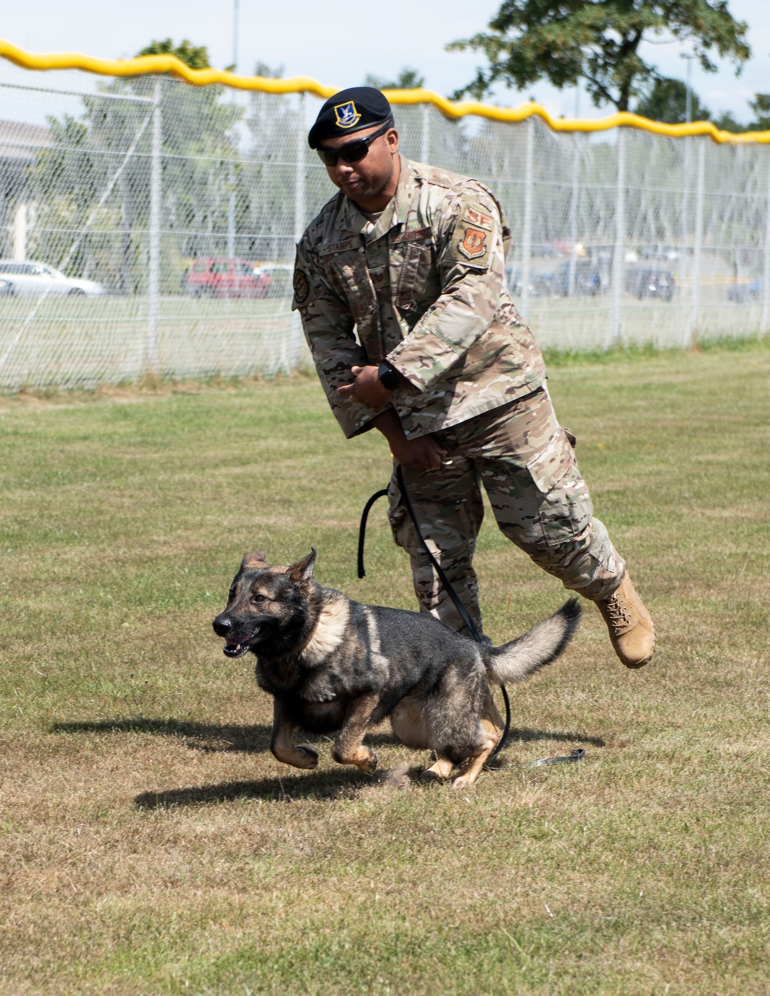 U.S. Air Force Tech. Sgt. Dontae Stamps, 52nd Security Forces Squadron military working dog handler, releases Axel, an MWD, at Spangdahlem Air Base, Germany, July 22, 2020. Stamps and Axel worked together to demonstrate preventing an intruder from entering their post. (U.S. Air Force photo by Senior Airman Melody W. Howley)