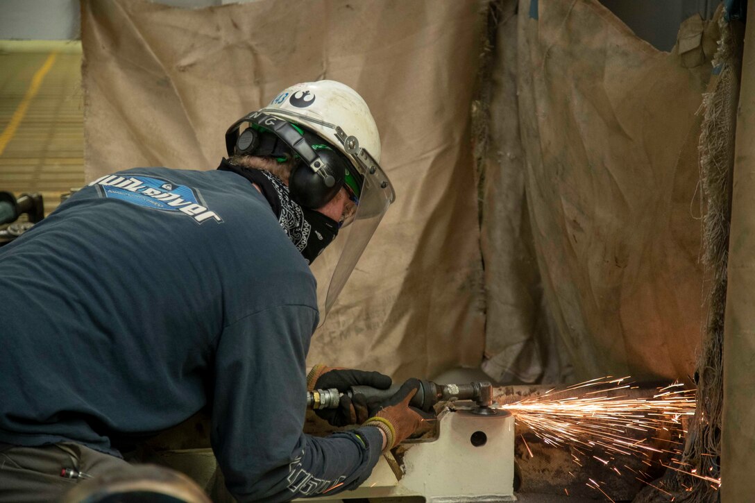 A Newport News Shipbuilding (NNS) worker grinds in USS Gerald R. Ford's (CVN 78) advanced weapons elevator (AWE) 1, July 18, 2020.
