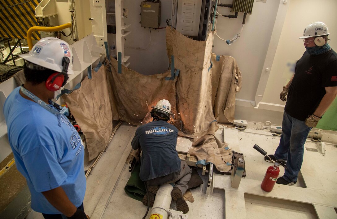 A Newport News Shipbuilding (NNS) worker grinds in USS Gerald R. Ford's (CVN 78) advanced weapons elevator (AWE) 1, July 18, 2020.