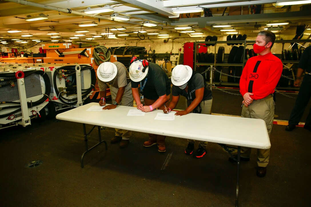 Lt. Cmdr. Paul Castillo, right, from San Diego USS Gerald R. Ford's Ordnance Handling Officer, takes possession of Lower Stage Weapons Elevator (LSWE) 1 for ford, July 22, 2020