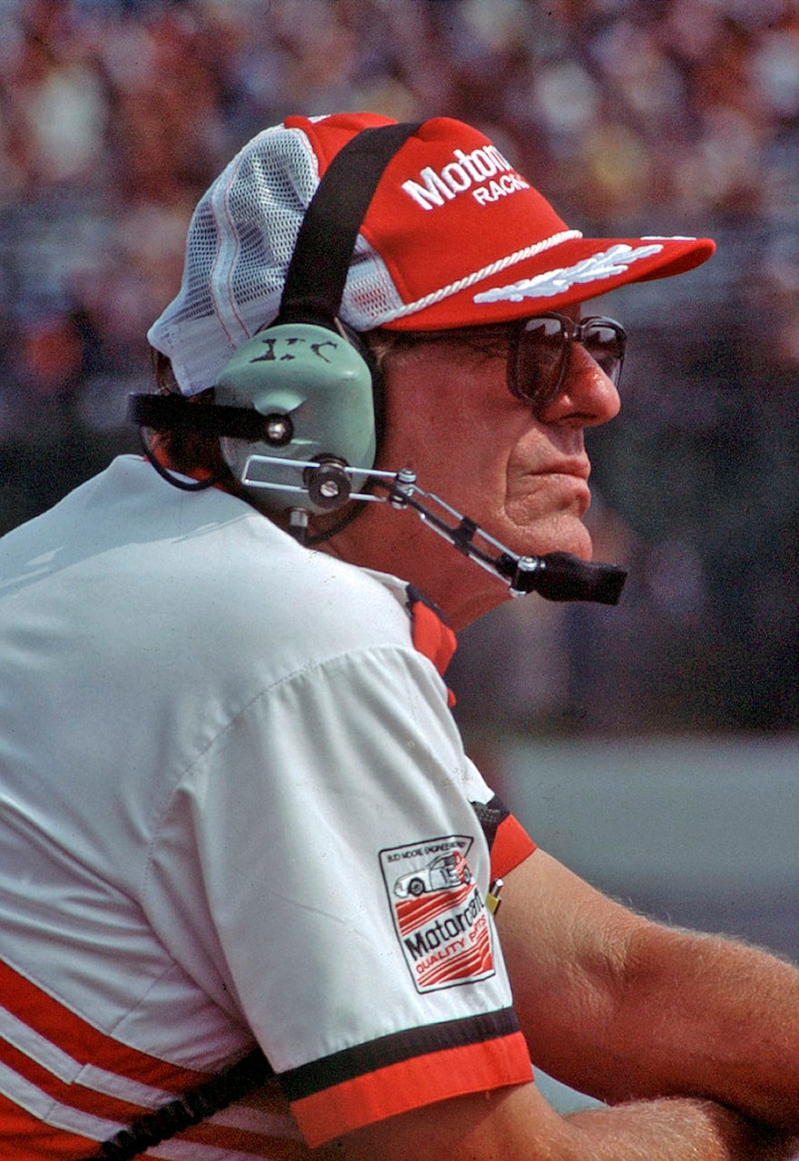 A man wearing a cap and headphones stares into the distance.