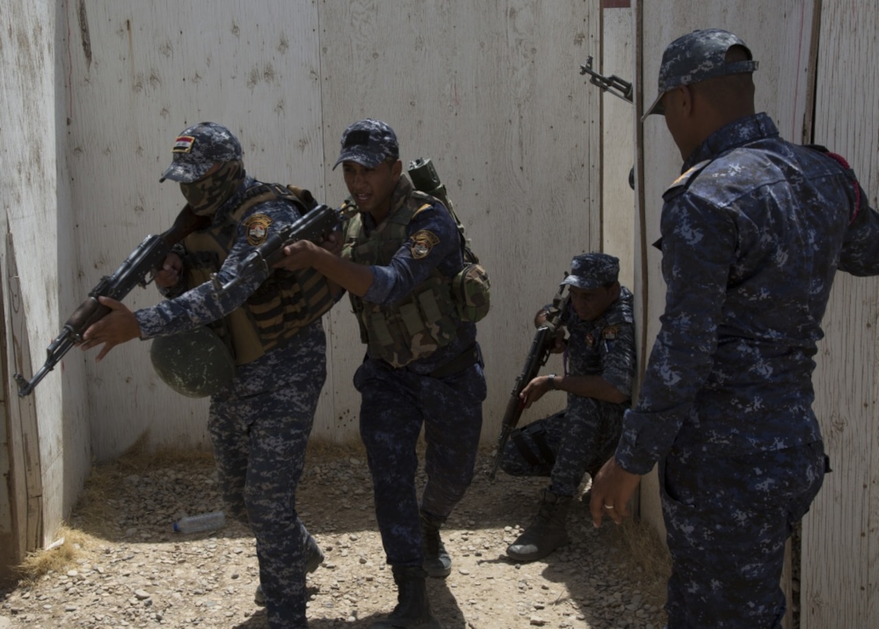 Four members of the Iraq Federal Police conduct an exercise.