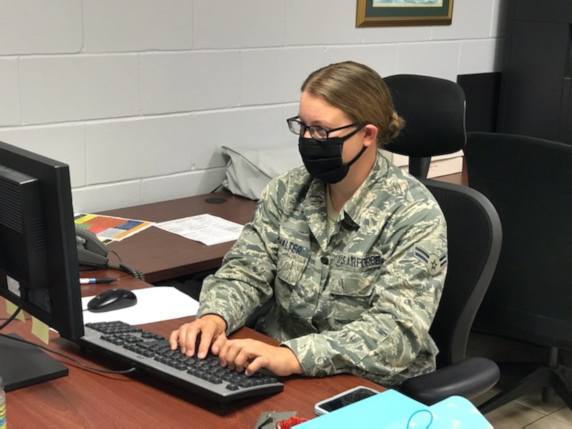 Airman First Class Robin Burkhalter, a personnel journeyman with the 186th Maintenance Group, works at her desk while wearing a hand-made face mask at Key Field Air National Guard Base, Meridian, Mississippi, May 6, 2020.