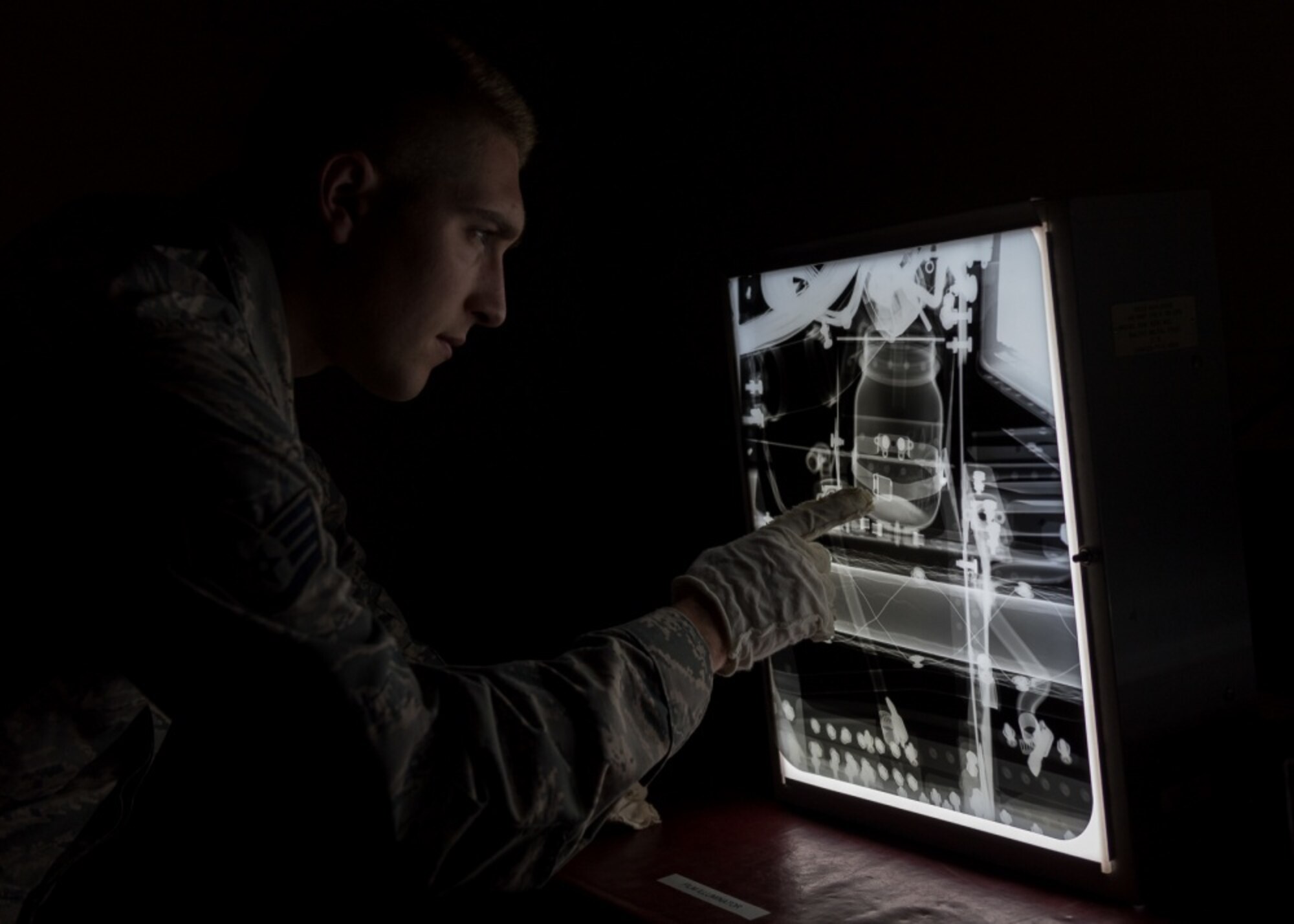 Staff Sgt. Tanner Wentworth, a Nondestructive Inspection Technician of the 101st Air Refueling Wing, Bangor Maine, studies an x-ray, June 25, 2018. The x-rays help detect faults in aircraft and equipment.