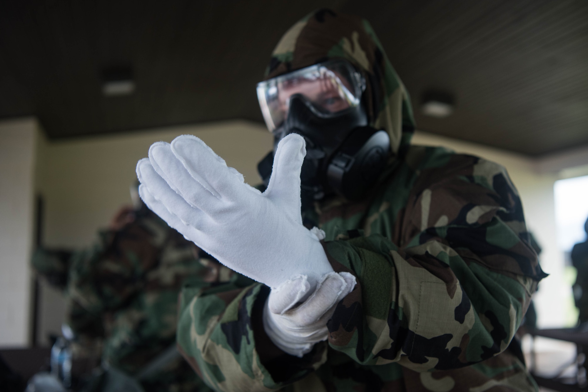 Tech. Sgt. Christian Parris, 22nd Aircraft Maintenance Squadron instrument and flight control systems craftsman, dons mission-oriented protective posture gear during a Chemical, Biological, Radiological and Nuclear survival skills class, July 21, 2020, at McConnell Air Force Base, Kansas. MOPP gear is personal protective equipment worn by Airmen in a contaminated environment to minimize bodily contact to harmful chemicals. (U.S. Air Force photo by Senior Airman Alexi Bosarge)
