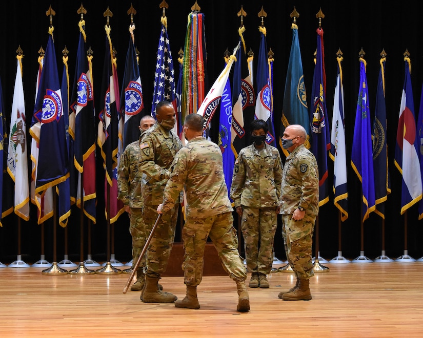 five soldiers pass a flag.