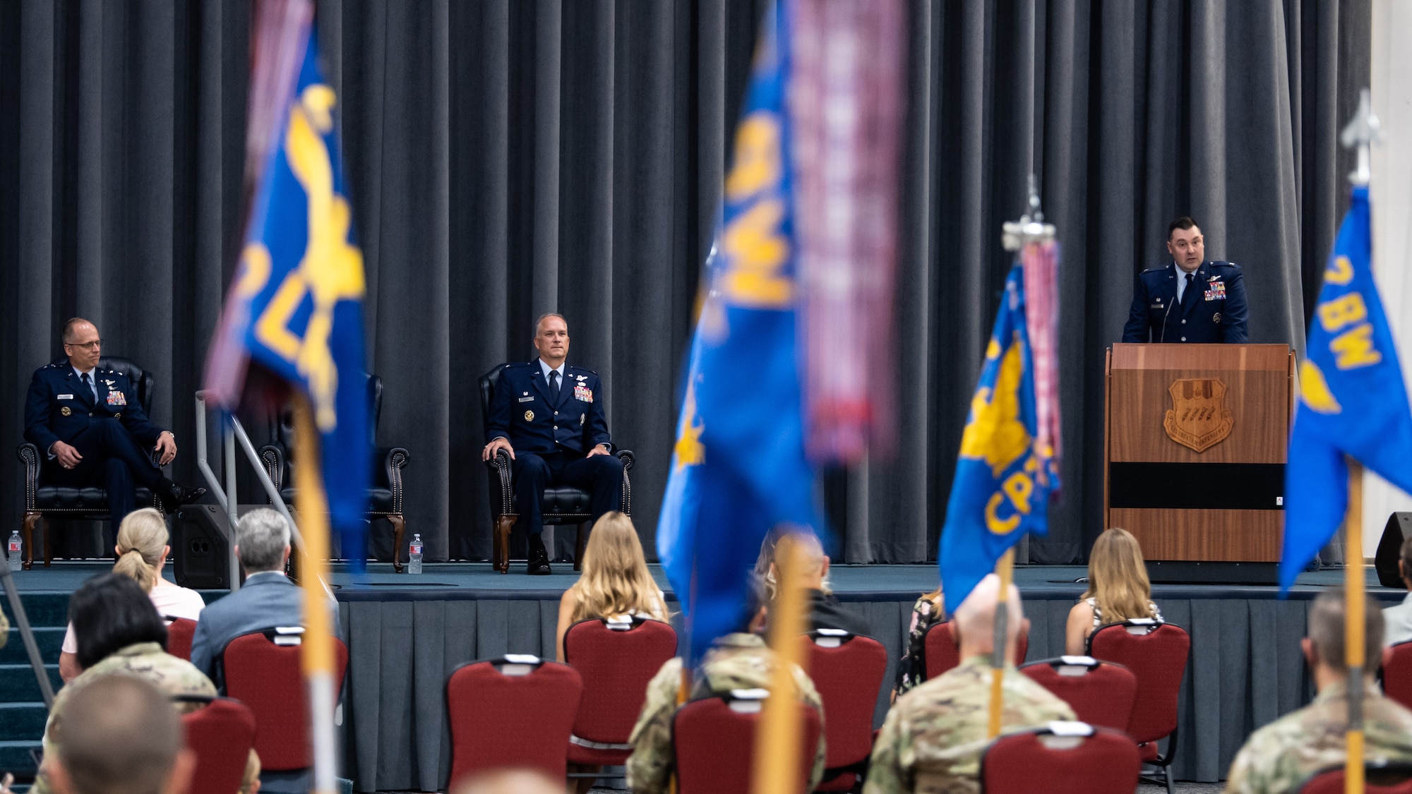 Maj. Gen. Mark E. Weatherington, 8th Air Force and Joint-Global Strike Operations Center commander, and Col. Michael A. Miller, outgoing 2nd Bomb Wing commander, listen to Col. Mark C. Dmytryszyn, incoming 2nd BW commander, address the crowd during a change of command ceremony at Barksdale Air Force Base, La., July 23, 2020. A change of command is a military tradition that represents a formal transfer of authority and responsibility for a unit from one commanding or flag officer to another. (U.S. Air Force photo by Airman 1st Class Jacob B. Wrightsman)