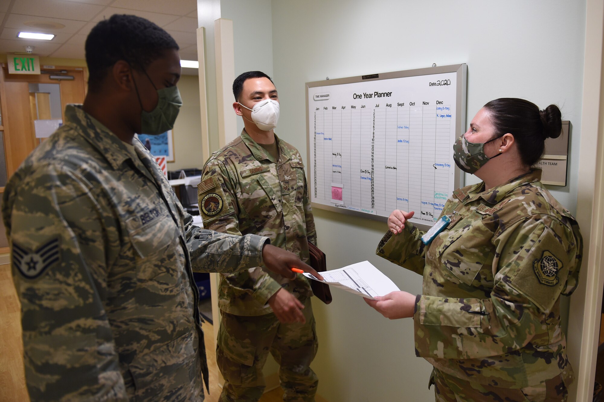 Staff Sgt. Malcom Belton, 62nd Medical Squadron Public Health technician, left, and Staff Sgt. Kim Springer, 62nd MDS Force Health NCO in charge, right, help a patient with their medical pre-deployment checklist at the McChord Clinic on Joint Base Lewis-McChord, Wash., July 20, 2020. Deployment medicine ensures members are medically qualified to deploy, administers all the pre- and post-deployment related health assessments and ensures all deploying members are aware of potential health risks in their theater of operation. (U.S. Air Force photo by Airman 1st Class Mikayla Heineck) (Portions of this photo are obscured to maintain OPSEC)