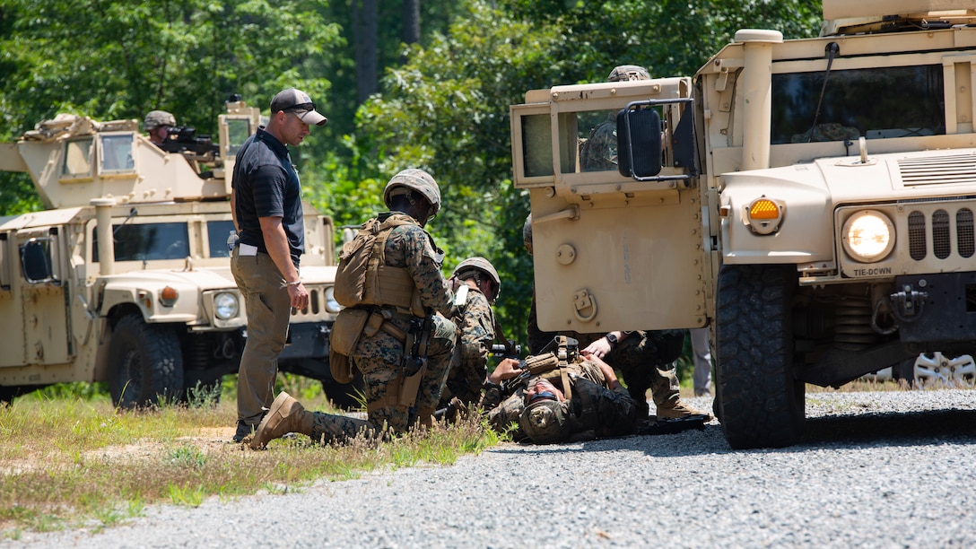 U.S. Marines with Charlie Company, 3rd Platoon, Marine Corps Security Forces, U.S. Marine Corps Forces Command, Fleet Marine Force Atlantic, applies simulated medical aid amid an ambush during a Mission Readiness Exercise (MRX) July 21, 2020, on Fort A. P. Hill in Port Royal, Virginia. Fleet Antiterrorism Security Team (FAST) platoons execute MRX exercises prior to deployment to evaluate the platoons’ proficiency in core mission essential tasks. (U.S. Marine Corps Photo by Lance Cpl. Jack Chen/Released)