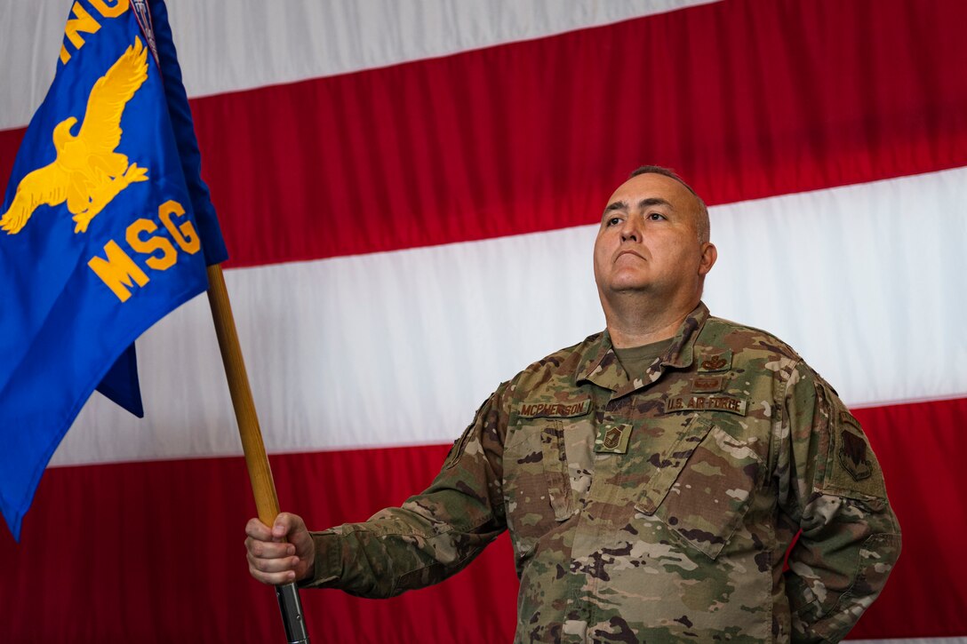 A photo of an Airman holding a guidon