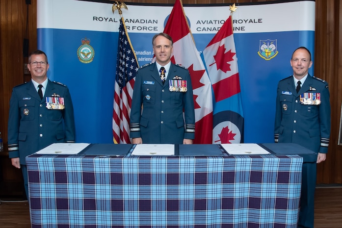 (From left) Incoming 1 Canadian Air Division/Canadian NORAD Region Commander Major-General Eric Kenny, Royal Canadian Air Force Commander Lieutenant-General Al Meinzinger, and outgoing 1 CAD/CANR Commander Lieutenant-General Alain Pelletier prepare to sign 1 CAD Change of Command scrolls during a ceremony at 17 Wing Winnipeg, Manitoba, July 6, 2020.