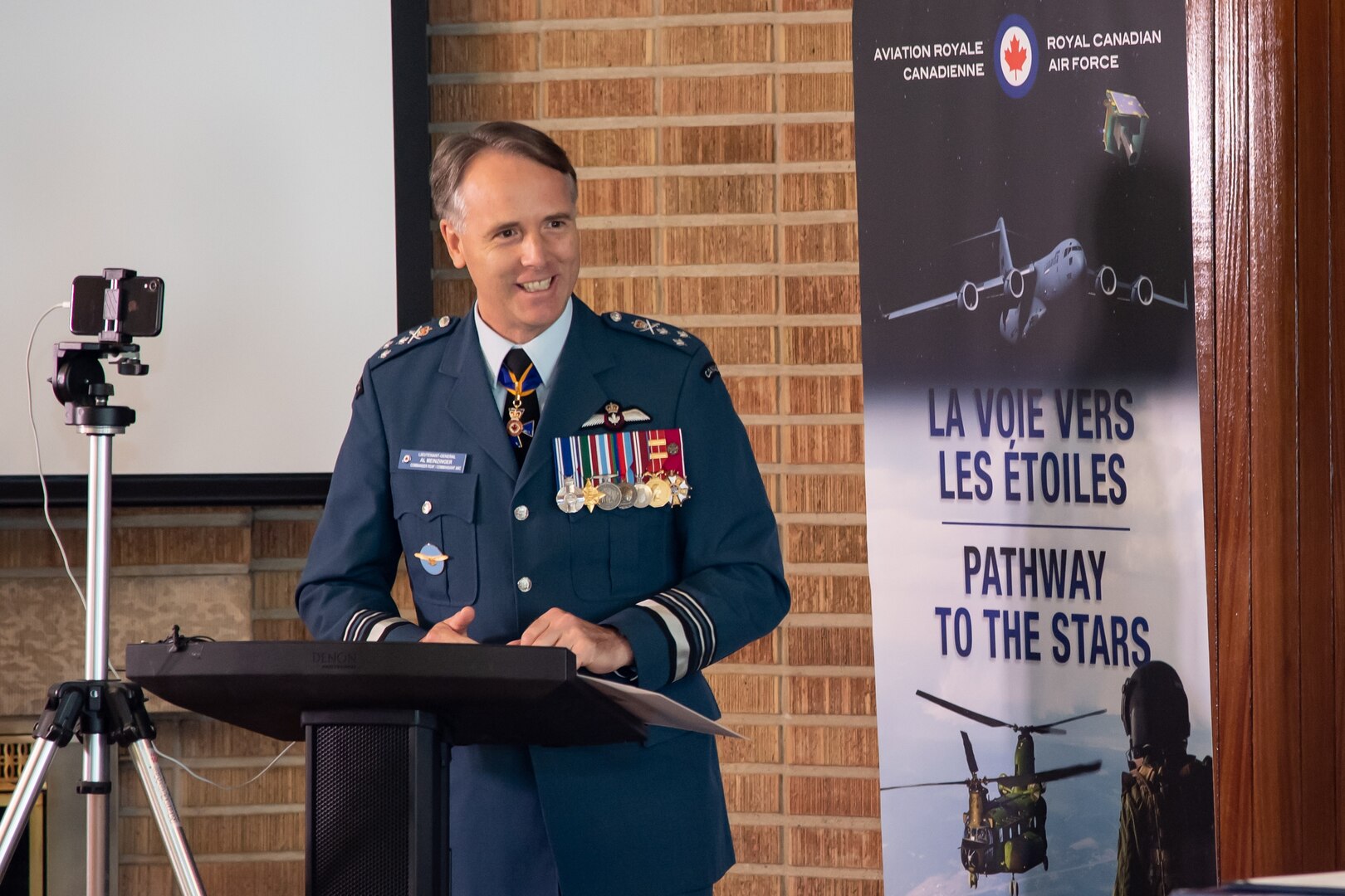 (From left) Incoming 1 Canadian Air Division/Canadian NORAD Region Commander Major-General Eric Kenny, Royal Canadian Air Force Commander Lieutenant-General Al Meinzinger, and outgoing 1 CAD/CANR Commander Lieutenant-General Alain Pelletier prepare to sign 1 CAD Change of Command scrolls during a ceremony at 17 Wing Winnipeg, Manitoba, July 6, 2020.