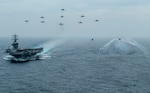 200602-N-VW723-1416 PACIFIC OCEAN (June 2, 2020) Aircraft from Nimitz Carrier Strike Group fly in formation over the aircraft carrier USS Nimitz (CVN 68) while an MH-60S Sea Hawk helicopter, from the "Battle Cats" of Helicopter Maritime Strike Squadron (HSM) 73. Nimitz is underway conducting composite training unit exercise (COMPTUEX). COMPTUEX is an intensive exercise designed to fully integrate units of the carrier strike group, while testing a strike group's ability as a whole to carry out sustained combat operations from the sea. (U.S. Navy photo by Mass Communication Specialist 3rd Class Keenan Daniels/Released)