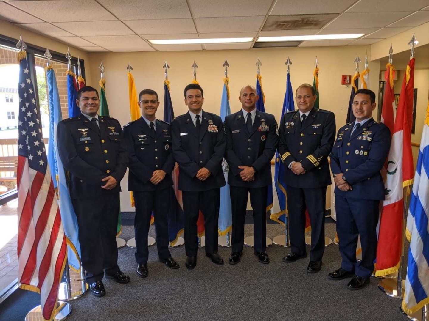 International and American service members, Professional Military Education instructors, pose for a photo at the IAAFA headquarters building. From left to right, Major Ronand Castillo from El Salvador, Major Marcio Teixeira from Brazil, Major Eduardo Barajas, a flight commander from the US Air Force, Master Sgt. Aguedo Mendez a flight chief from the US Air Force, Chief Master Sgt. Elvis Garcia from Peru, and Master Sgt. Edwin Lara from Honduras.
