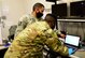 Two Airmen work on a customer's laptop at Creech Air Force Base, Nevada.