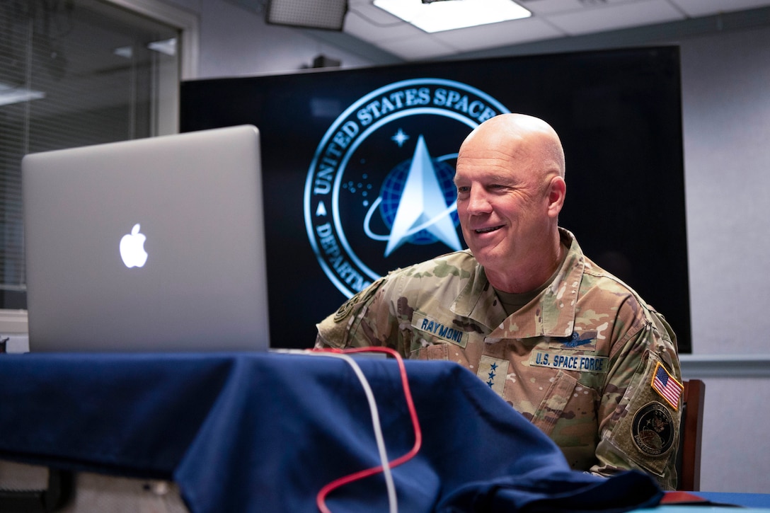 Man in a military uniform participates in a virtual face-to-face call via laptop.
