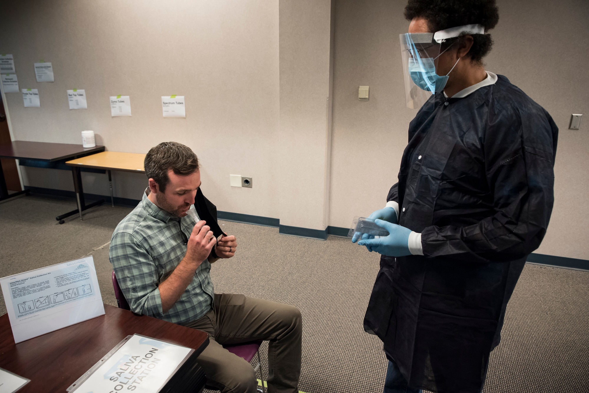 Air Force Research Laboratory team member Joshua Trice collects a saliva sample from a teammate during a dry-run preparation on July 22, 2020, for an upcoming research study. For this study, led by the 711th Human Performance Wing, researchers will collect samples from healthy Wright-Patterson AFB military, civilian, and contractor volunteers to evaluate emerging testing methodologies for detecting past and present COVID-19 infections. (U.S. Air Force photo/Richard Eldridge)