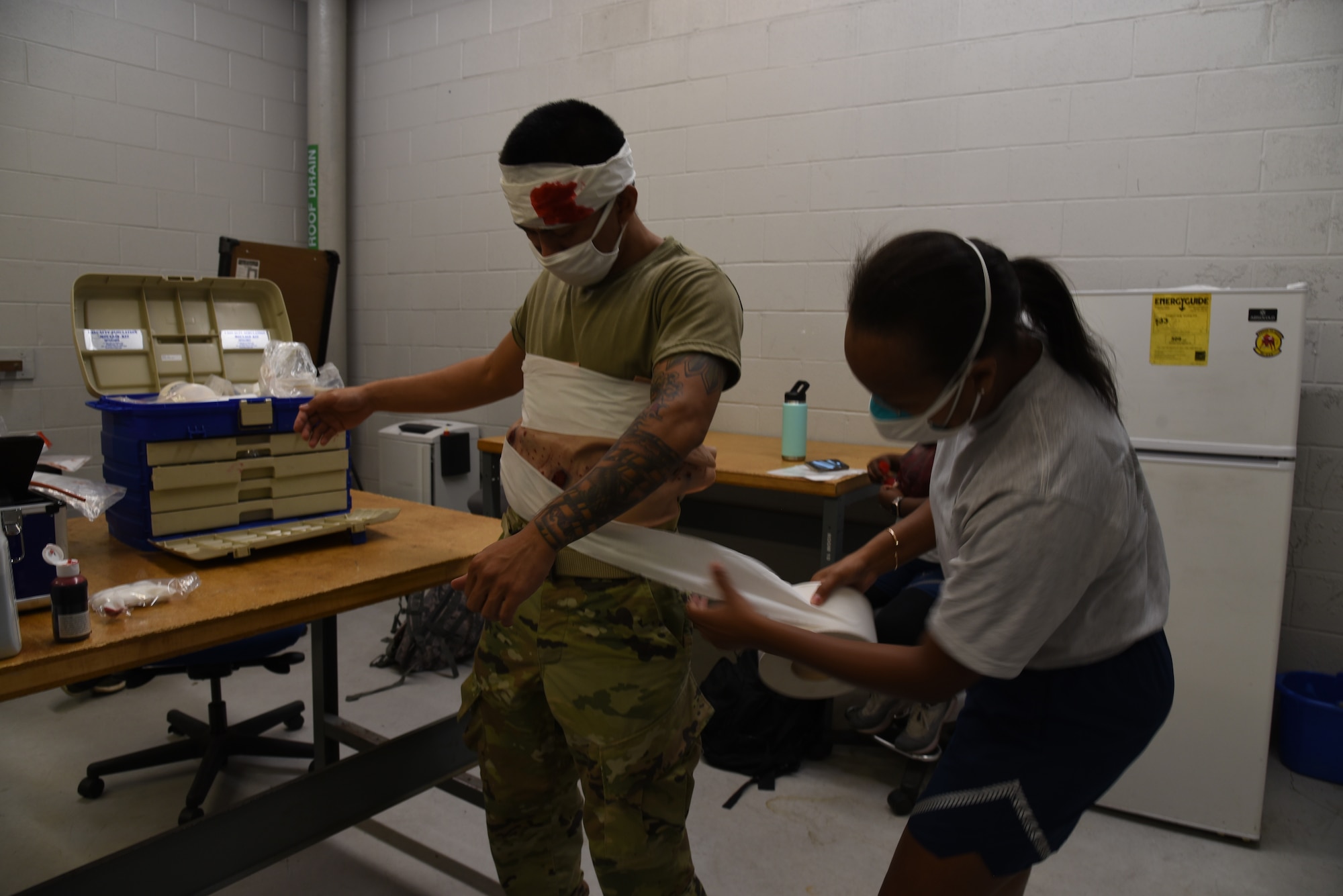 Capt. Loreen Goodwin, 36th Aeromedical Evacuation Squadron flight nurse, wraps a bandage around Staff Sgt. Calin Caracol, 36th AES medical technician, who was a simulated patient during a three-day training event, July 20-22, 2020 at Keesler Air Force Base and the Mississippi Air National Guard's Combat Readiness Training Center in Gulfport, Mississippi. Reserve Citizen Airmen from the 36th AES and Mississippi Air National Guardsmen from the 183rd AES came together for a joint training event between Reservists and Guardsmen to work as one team, while training on patient care and handling during a simulated air evacuation of injured service members. (U.S. Air Force photo by Jessica L. Kendziorek)