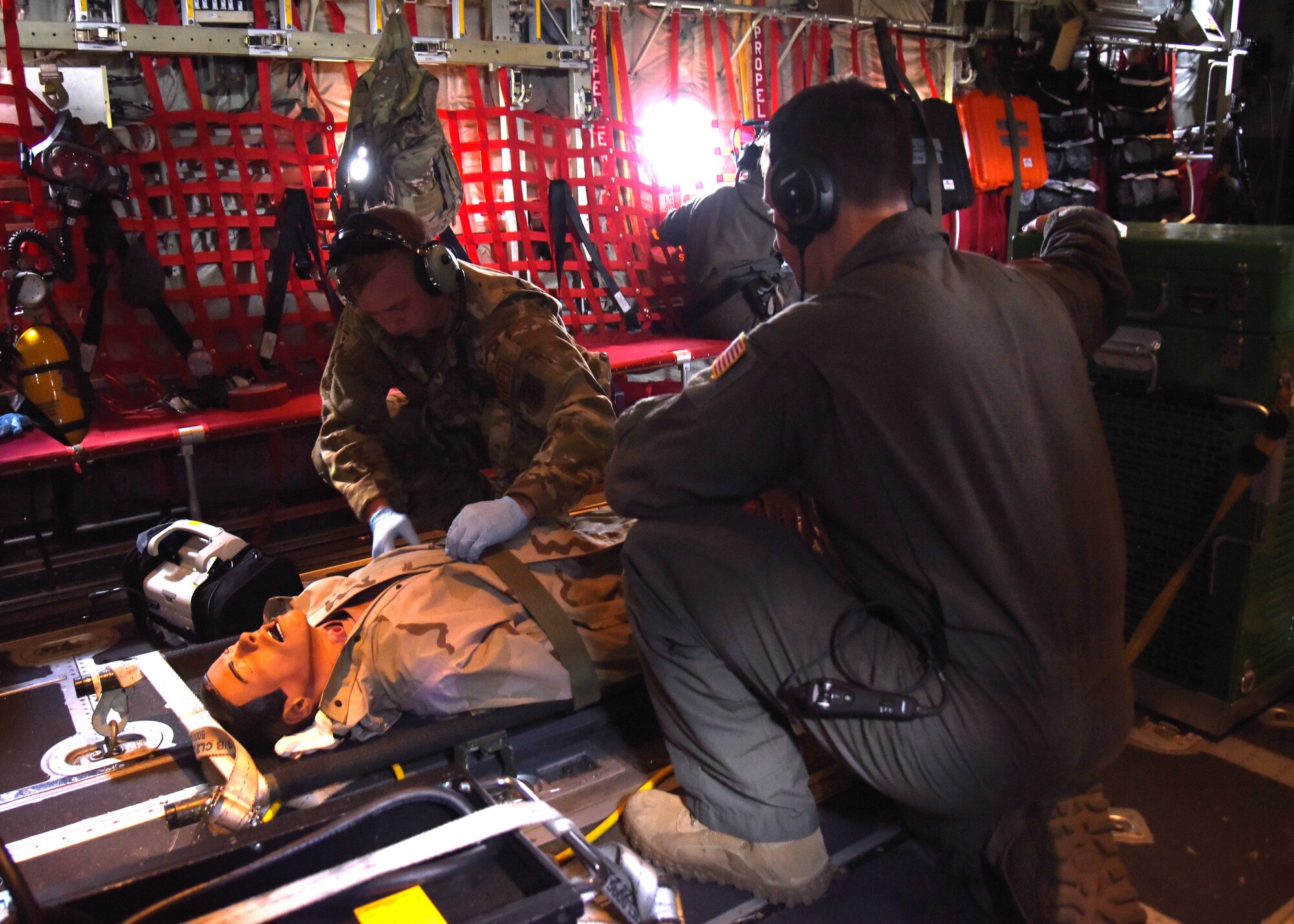 Tech Sgt. David McAlpin and Airman 1st Class Zachary Winstead, 183rd Aeromedical Evacuation Squadron medical technicians, check the vitals of the medical mannequin during a training flight on the C-130J Super Hercules during a three-day training event, July 20-22, 2020 at Keesler Air Force Base and the Mississippi Air National Guard's Combat Readiness Training Center in Gulfport, Mississippi. Reserve Citizen Airmen from the 36th AES and Mississippi Air National Guardsmen from the 183rd AES united for joint training to work as one team. They trained on patient care and handling during a simulated air evacuation of injured service members. (U.S. Air Force photo by Jessica L. Kendziorek)