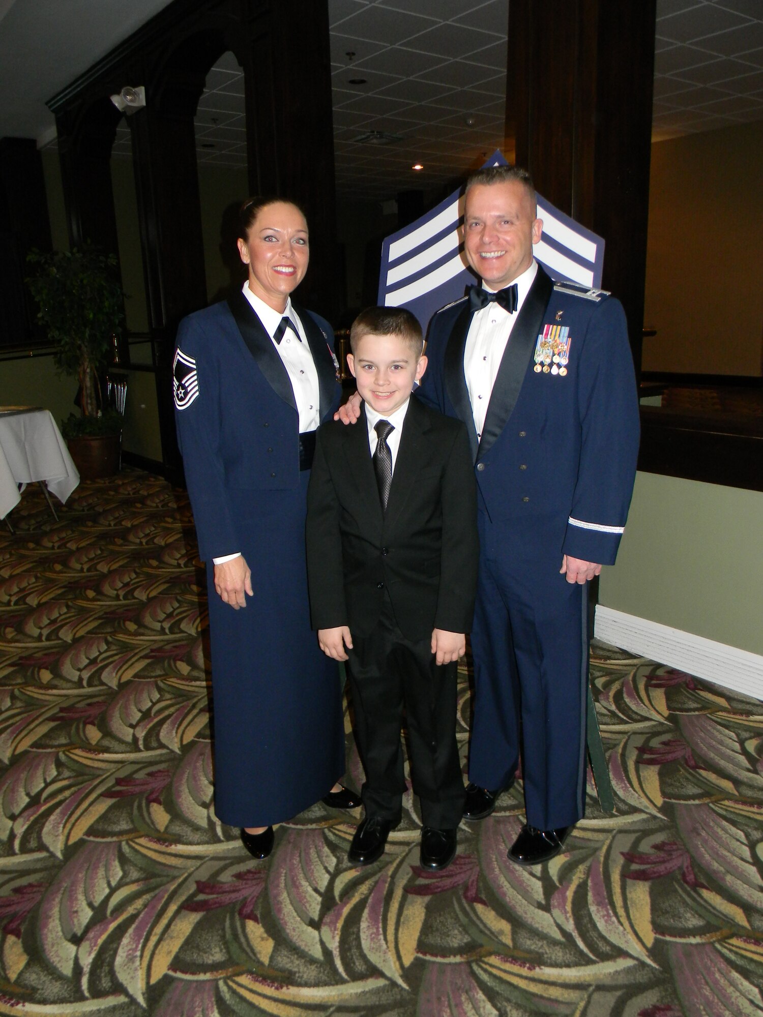 man and woman in uniform with their son